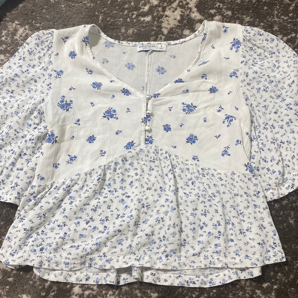 White top with blue floral flowers on it